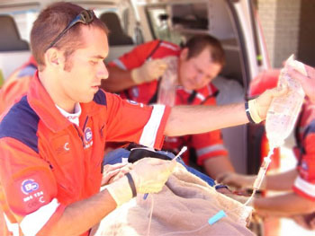 Imagen: Un paramédico preparando una infusión intravenosa para un paciente (Fotografía cortesía de Werner Vermaak).