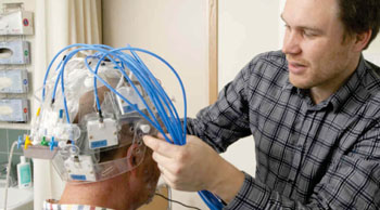 Imagen: El ingeniero biomédico, Andreas Fhager, ajusta el dispositivo Strokefinder (Fotografía cortesía de la Universidad Tecnológica de Chalmers).