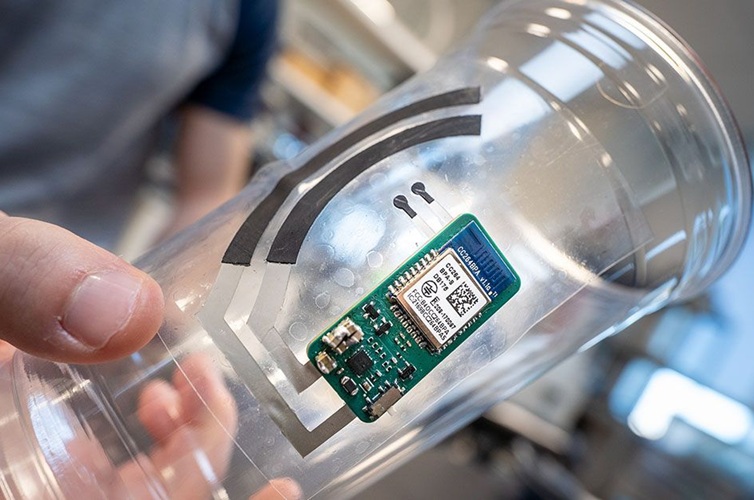 Imagen: la pegatina electrónica se adhiere a un vaso para beber y controla los niveles de vitamina C a partir del sudor de las yemas de los dedos (Foto cortesía de David Baillot/Escuela de Ingeniería Jacobs de UC San Diego)