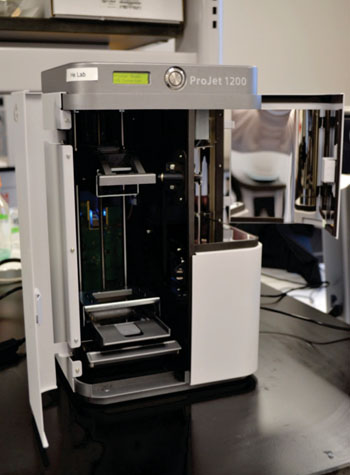 Imagen: La impresora Projet 1200 3D fue capaz de producir fácilmente y perfeccionar el dispositivo usando materiales amigables con el ambiente para hacer dispositivos de bajo costo, para los puntos de atención que detectan rápidamente la anemia a partir de una gota de sangre (Fotografía cortesía de la Universidad del Estado de Kansas).