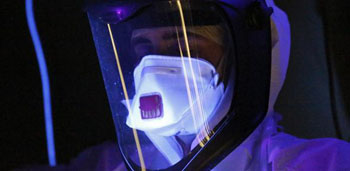 Imagen: Un cribado con luz ultravioleta para líquidos que contienen potencialmente el Ébola (Fotografía cortesía del Departamento para el Desarrollo Internacional DFID-Reino Unido).