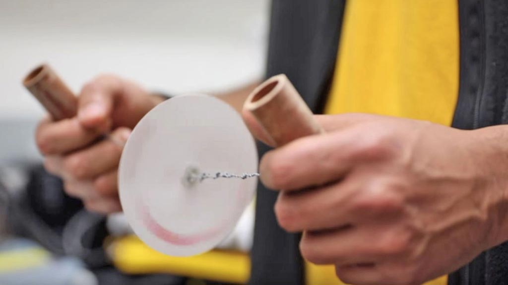 La papelfuga de bajo costo fue inspirada por el juguete torbellino, en el que un bucle de hilo se pasa a través de dos agujeros en un botón o un disco. Los extremos del bucle se agarran y luego se tiran rítmicamente. A medida que el hilo se enrolla y se desenrolla, el botón gira a alta velocidad. Unos bioingenieros diseñaron la papelfuga para concentrar los parásitos como la malaria en la sangre (Fotografía cortesía de la Universidad de Stanford).