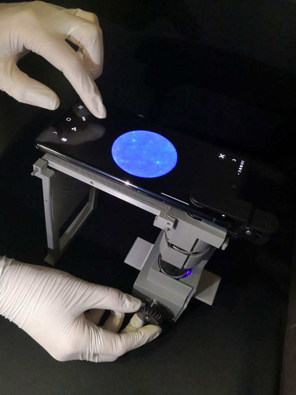 Imagen: Investigadores de la UArizona toman imágenes de una muestra usando un microscopio y un teléfono inteligente (Fotografía cortesía de la Universidad de Arizona)