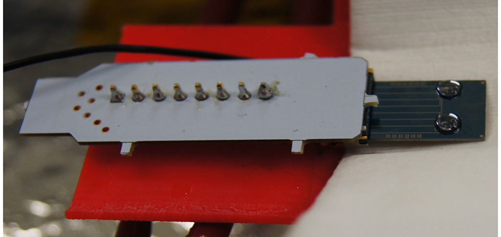 Imagen: chip de dispositivo de grafeno unido a un conector eléctrico con dos muestras de 5 μl de VHCcAg (Fotografía cortesía de la Universidad de Swansea)