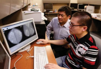 Imagen: Wei Qian, PhD y el estudiante de doctorado, Wenqing Sun, creando un sistema de predicción de riesgo de cáncer de mama (Fotografía cortesía de JR Hernández/UTEP News Service).