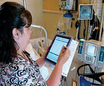 Image: Staff member filling in the iPad mini record (Photo courtesy of  Groote Schuur Hospital).