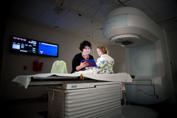Image: Child Life Specialist Amy Kennedy helps a patient prepare for RT (Photo courtesy of St. Jude Children\'s Research Hospital).