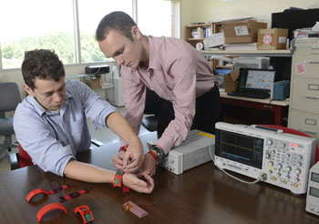 Image: Researchers work with the HET system wristband (Photo courtesy of NC State University).
