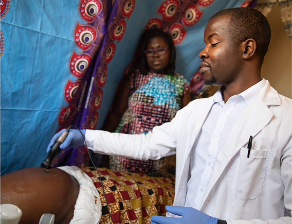 Image: A sonographer performing an ultrasound scan in Zambia (Photo courtesy of UNC School of Medicine) Image: A sonographer performing an ultrasound scan in Zambia (Photo courtesy of UNC School of Medicine)