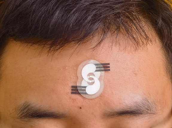 Image: The electrochemical sensor can be placed on the forehead to gain real-time data on neurological conditions (Photo courtesy of Penn State)