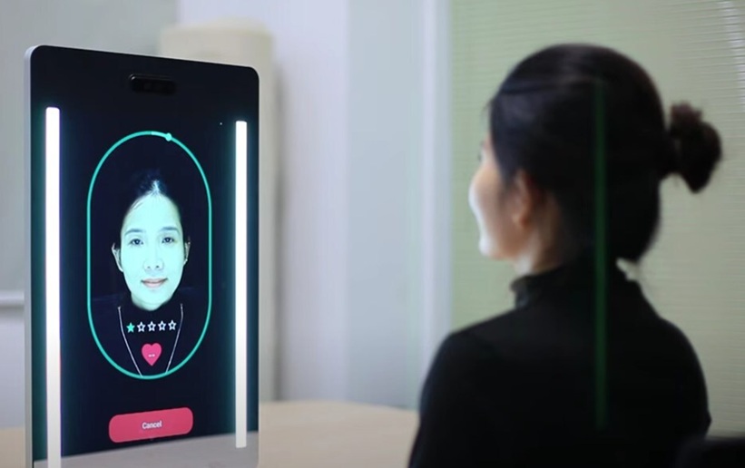 Image: A young woman completes a 30-second health scan using the Anura MagicMirror (Photo courtesy of Nuralogix)