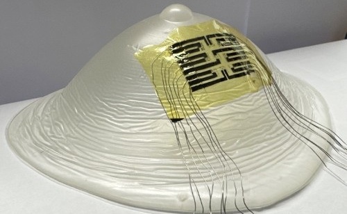 Image: The ultra-thin temperature-sensing patch shown on a model breast (Photo courtesy of University of Bristol)