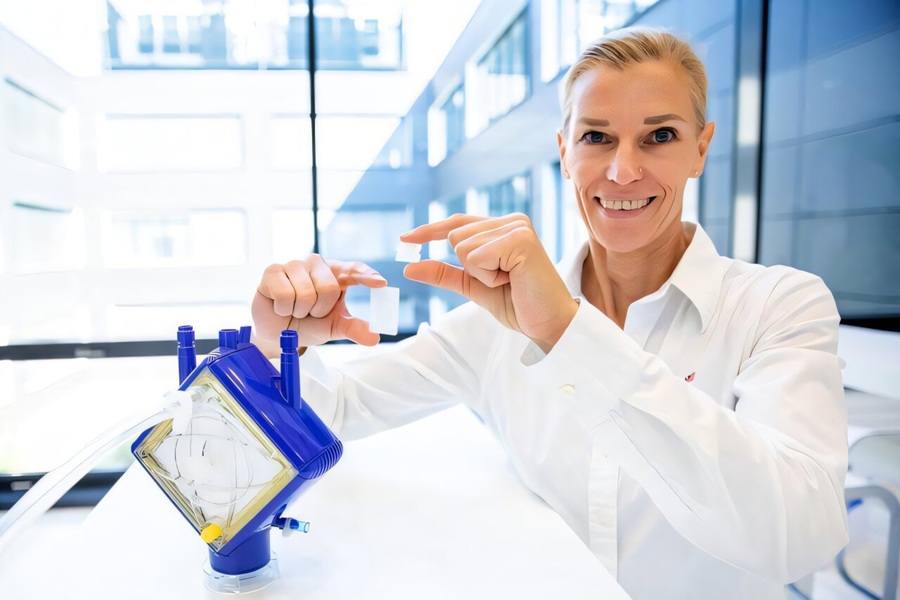 Image: Smaller and more efficient: Prof. Dr Bettina Wiegmann demonstrates the new TPMS membrane architecture (right) in comparison with the conventional hollow-fibre membrane bundles from an ECMO lung support system. (Image Credit: Karin Kaiser/MHH)
