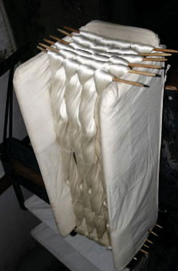 Image: Raw silk from domesticated silk worms, showing its natural shine (Photo courtesy of Wikimedia Commons).