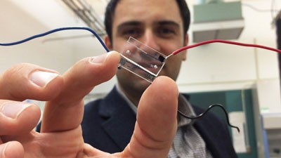 Image: A hybrid microfluidic chip (held by Dr. Fatih Sarioglu) uses a simple circuit pattern to assign a unique seven-bit digital identification number to each cell passing through the channels (Photo courtesy of the Georgia Institute of Technology).