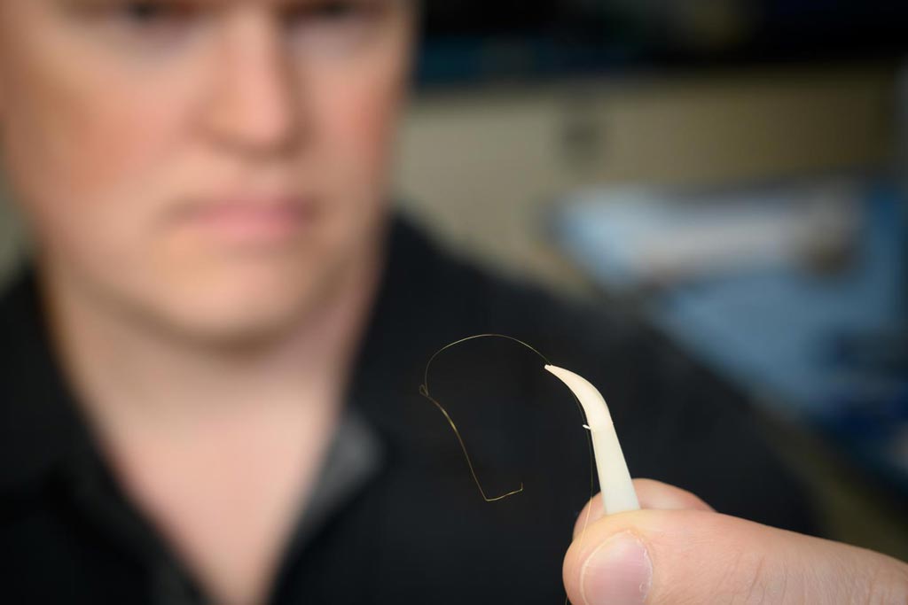 Image: Dr. Brian Geiss displays a gold microwire that is one-fourth the size of a human hair (Photo courtesy of John Eisele, Colorado State University Photography).