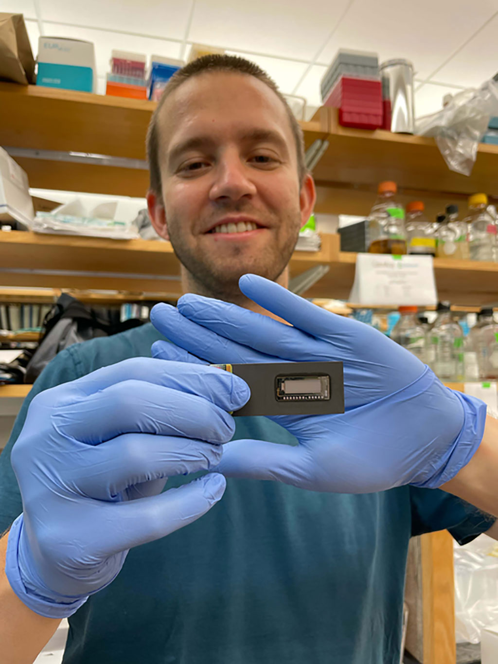 Image: Lead author, Karl Barber with a PICASSO microarray (Photo courtesy of Karl Barber, Schmidt Science Fellows)