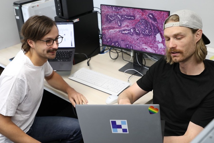 image: Researchers Marco Gustav (right) and MD Nic G. Reitsam (left) discuss the study data (Photo courtesy of Anja Stübner/EKFZ)