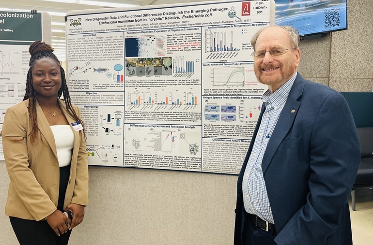 Image: Doctoral student Pelumi Oladipo and advisor Jeffrey Ram, Ph.D., presented their research at a recent poster session (Photo courtesy of Wayne State University) Image: Doctoral student Pelumi Oladipo and advisor Jeffrey Ram, Ph.D., presented their research at a recent poster session (Photo courtesy of Wayne State University)