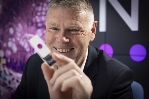 Image: Professor David Brettle, Chief Scientific Officer at Leeds Teaching Hospitals NHS Trust with a pathology slide showing the TANGO technology (Photo courtesy of Leeds Teaching Hospitals NHS Trust)