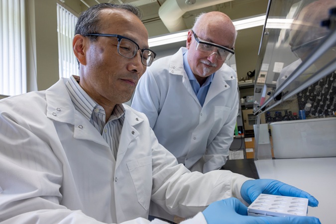 Image: University of Florida scientists Hugh Fan, Ph.D., and John Lednicky, Ph.D., led the development of a cost-effective, accurate handheld device capable of simultaneously testing for seven different mosquito-borne viruses. (Image Credit: UF Health photo by Hannah Clark)