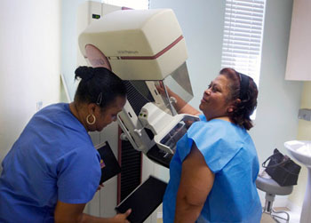 Image: A screen-film mammography exam in progress in a cancer detection center (Photo courtesy of AP/Damian Dovarganes).