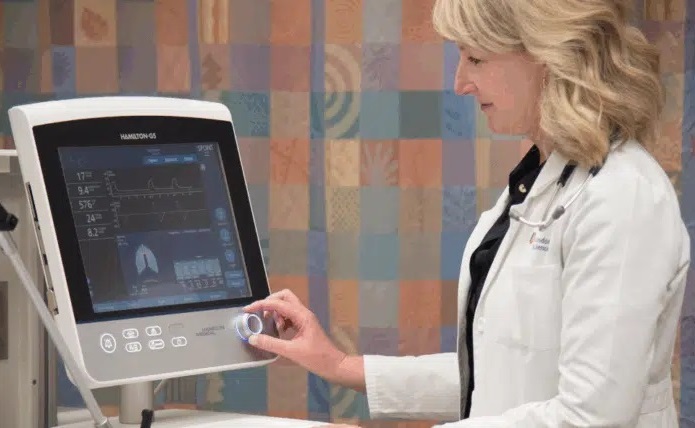 Imagen: Dra. Karen Bosma seleccionando un modo en una máquina de ventilación (foto cortesía de LHSC)