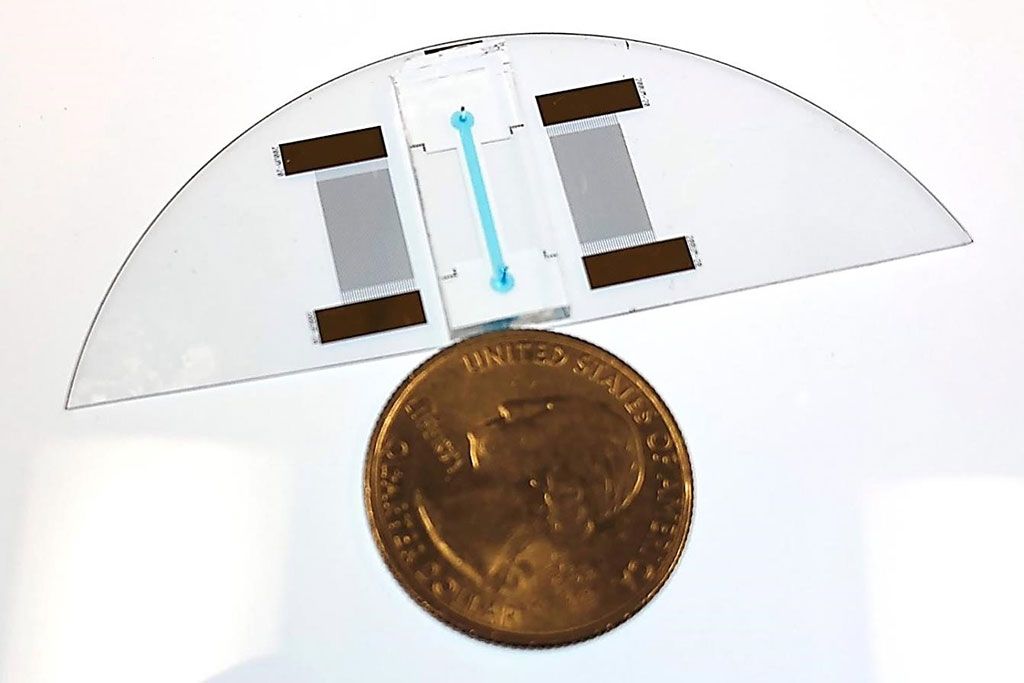 Imagen: Se muestra un dispositivo “lab-en-un-chip” para un Análisis de Desplazamiento Térmico Acústico, junto a una moneda de un cuarto de dólar estadounidense para comparar el tamaño. El dispositivo puede diagnosticar la anemia de células falciformes (Fotografía cortesía de la Facultad de Ingeniería y Ciencias Aplicadas de la CU Boulder).