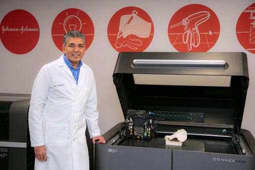 Image: Sam Onukuri with the Objet Connex500 PolyJet 3D printer (Photo courtesy of JNJ).