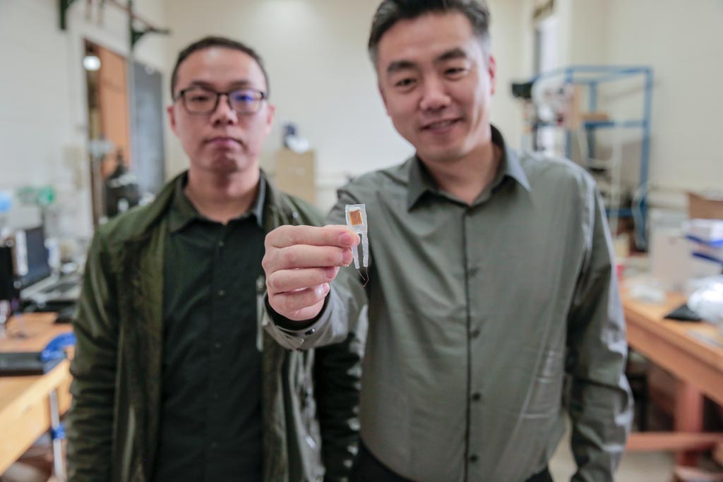 Image: Graduate student Guang Yao (L) and Professor Xudong Wang (R) with the implantable device (Photo courtesy of Sam Million-Weaver/ WISC).
