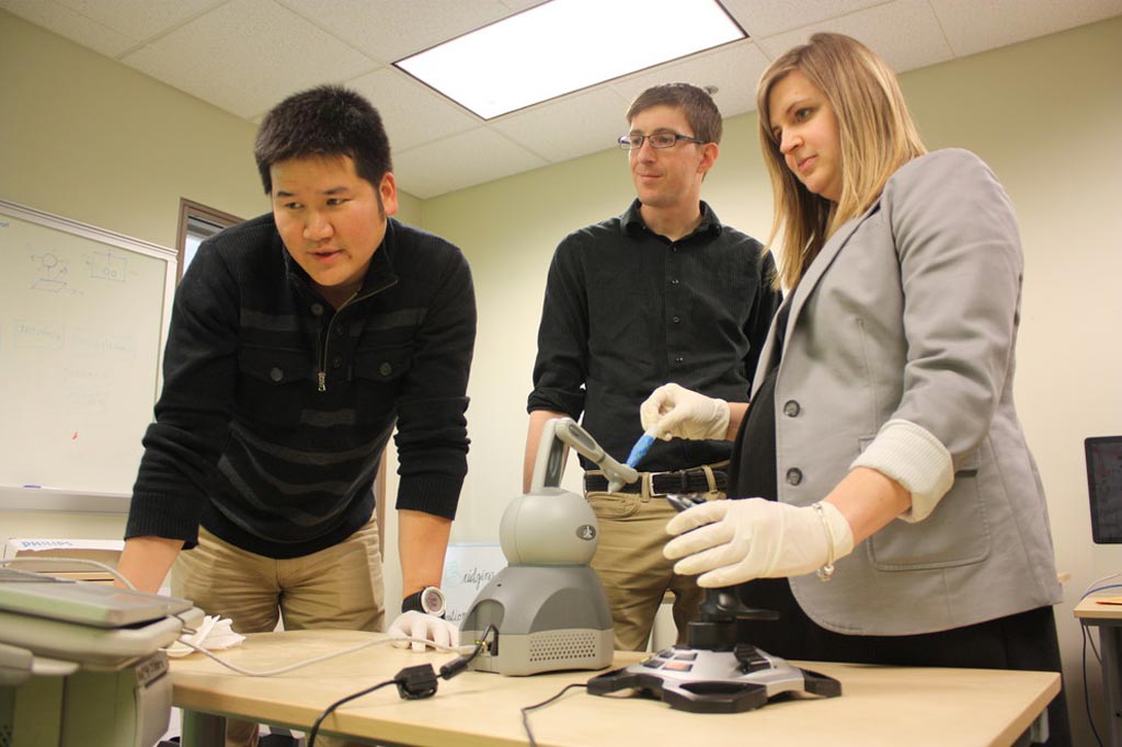 Image: Dr. Scarlett Miller demonstrating the prototype haptic robotic training system (Photo courtesy of Shea Winton/ PSU).