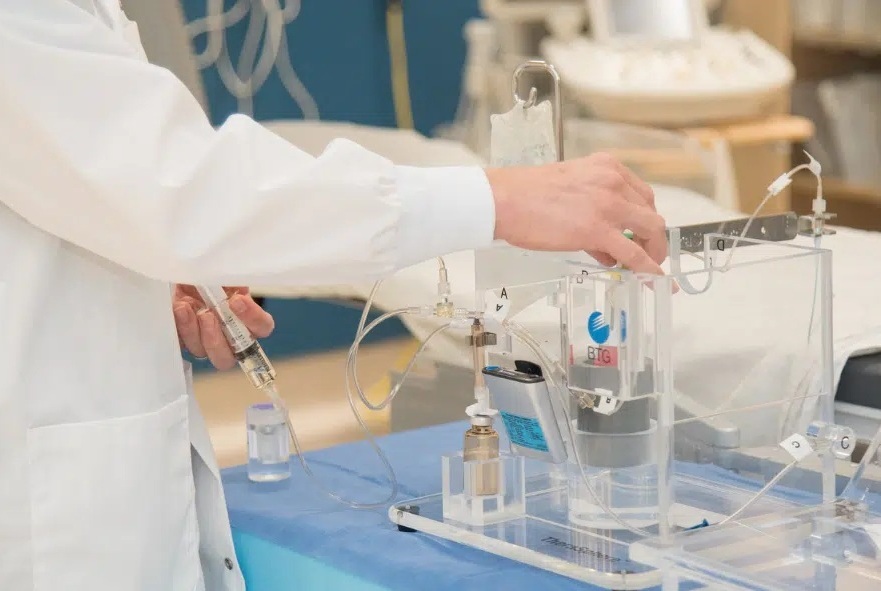 Image: Dr. Derek Cool demonstrating the equipment used to deliver radioactive beads to treat patients with kidney cancer (Photo courtesy of LHSC)