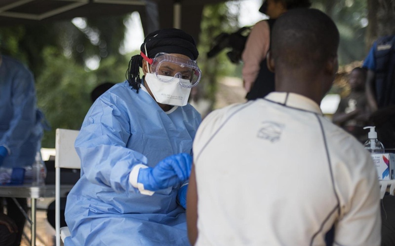 Image: A member of the WHO Ebola ring vaccination team vaccinates a man in Bosolo village during a 2018 Ebola outbreak in Congo (Photo courtesy of WHO/Lindsay Mackenzie)
