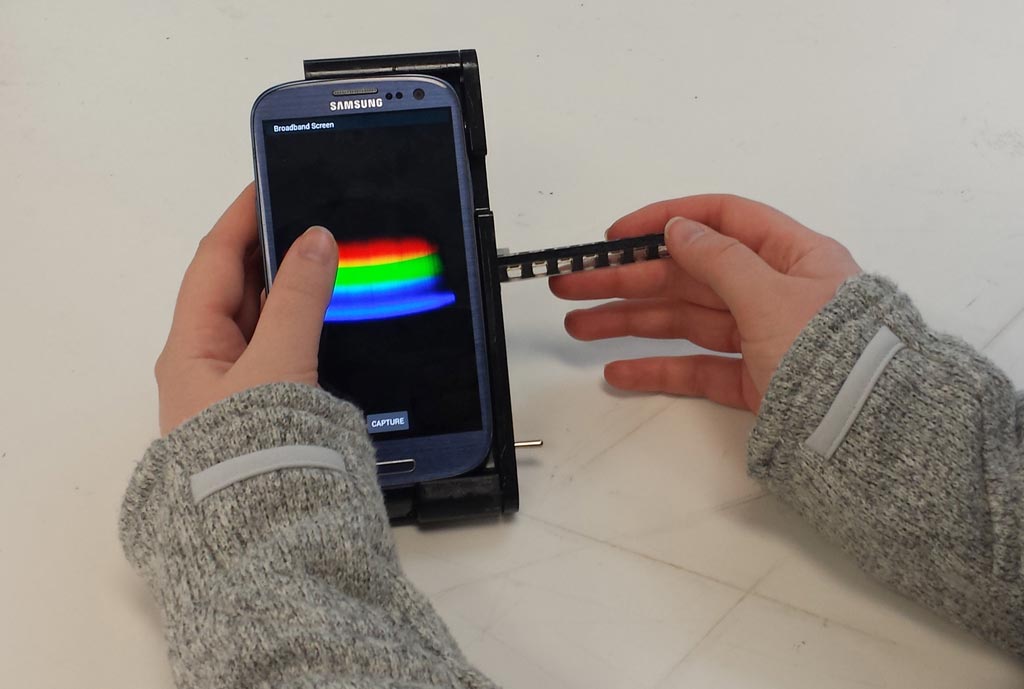 Image: The spectral transmission-reflectance-intensity (TRI)-Analyzer attaches to a smartphone and analyzes patient blood, urine, or saliva samples as reliably as clinic-based instruments that cost thousands of dollars (Photo courtesy of the Department of Bioengineering, University of Illinois at Urbana-Champaign).