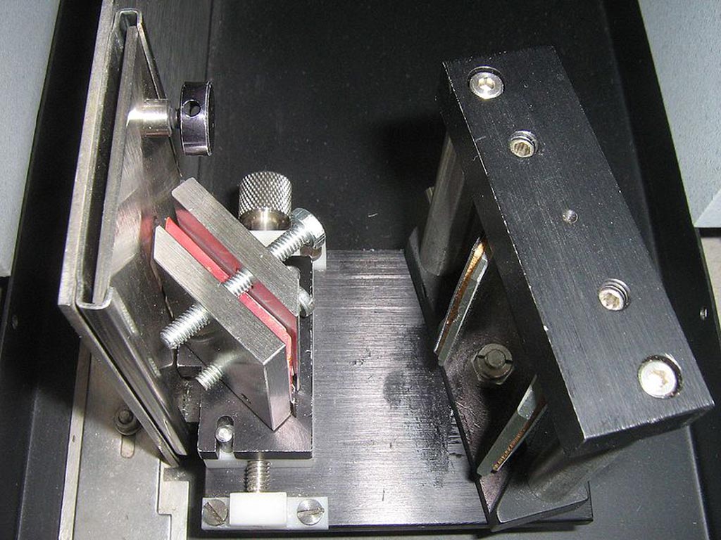 Image: An ATR attachment for infrared spectroscopy. The sample is in the steel containers either side of the pink crystal (Photo courtesy of Wikimedia Commons).
