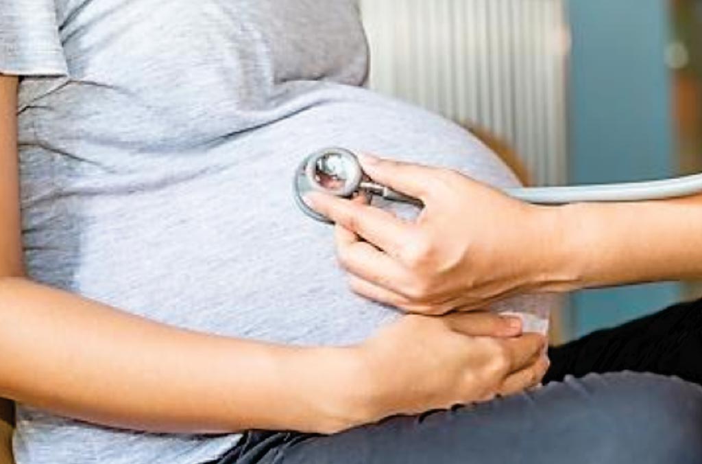 Image: A pregnant woman with a stethoscope placed to her stomach. Scientists have developed a test to predict a woman\'s risk of preterm birth (Photo courtesy of University of California - San Francisco).