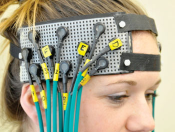 Image: Participant fitted with fNIRS headgear (Photo courtesy of University of Pittsburgh Schools of the Health Sciences).