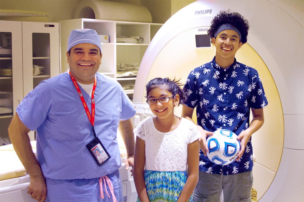 Image: Karun Sharma, MD, PhD, director of Interventional Radiology, Children\'s National Health System, with two children who were treated for osteoid osteoma using the non-invasive MR-HIFU technique (Photo courtesy of Cision CR Newswire).